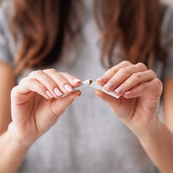 Woman breaking cigarette in half